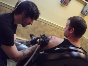 Ryan tattooing client Andrew